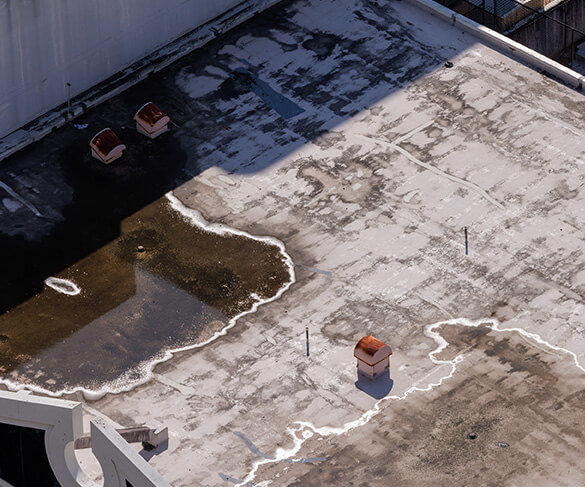 Aerial view of a flat roof with ponding water and sagging drainage areas